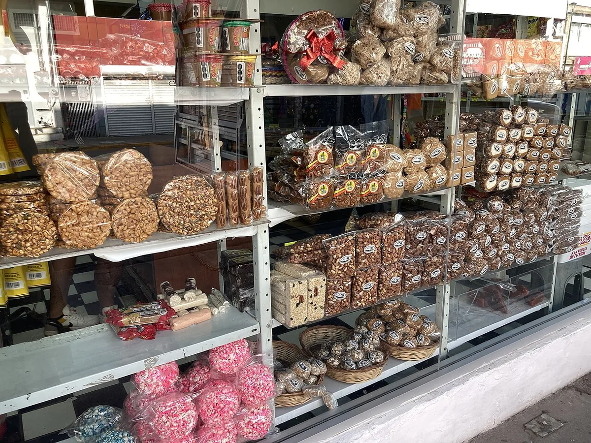A dulcería window: palanquetas, jamoncillos, and milk candies stacked for gift boxes