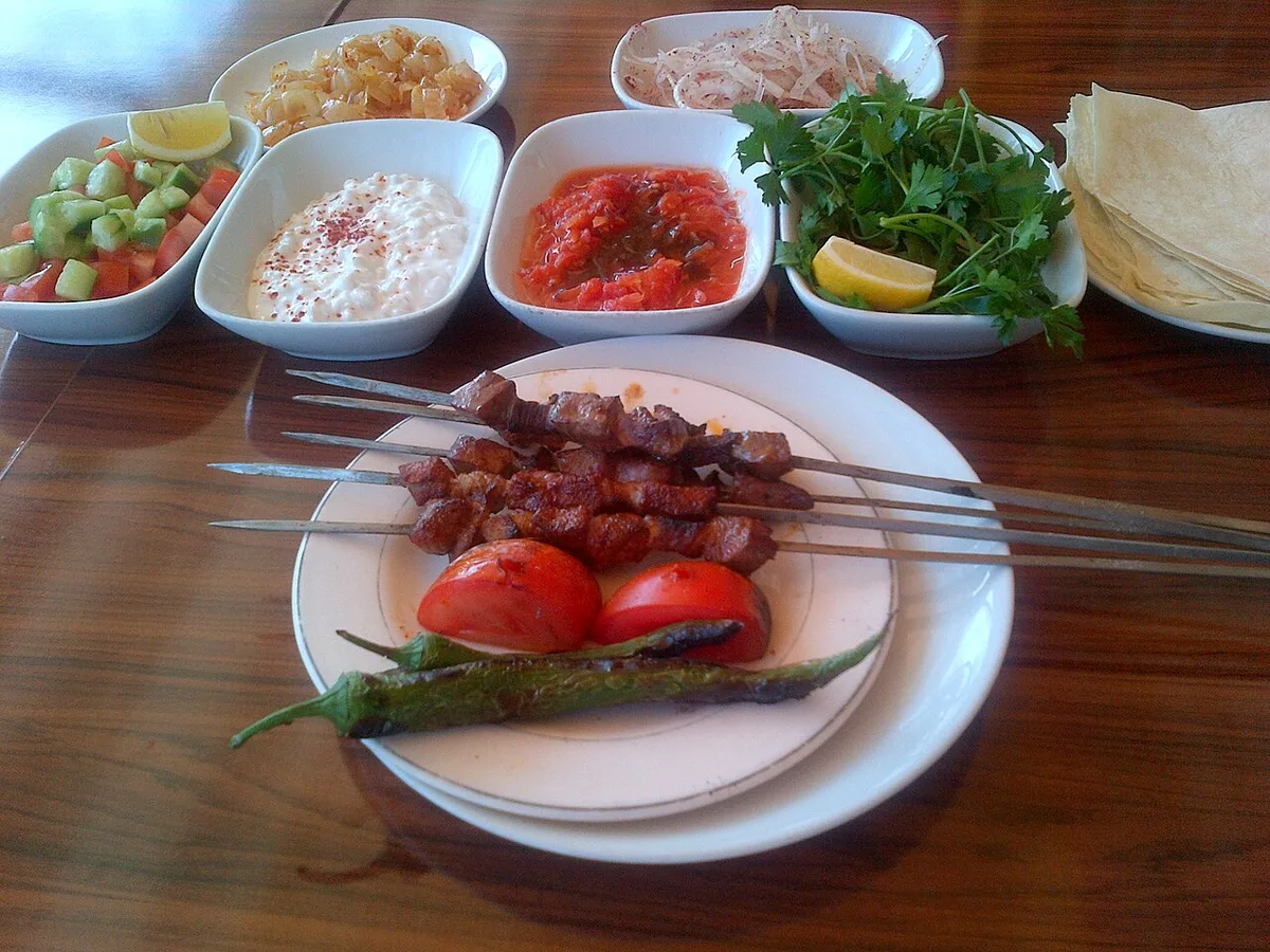 Kebab skewers with the full spread of salads and sides at a kebab salon
