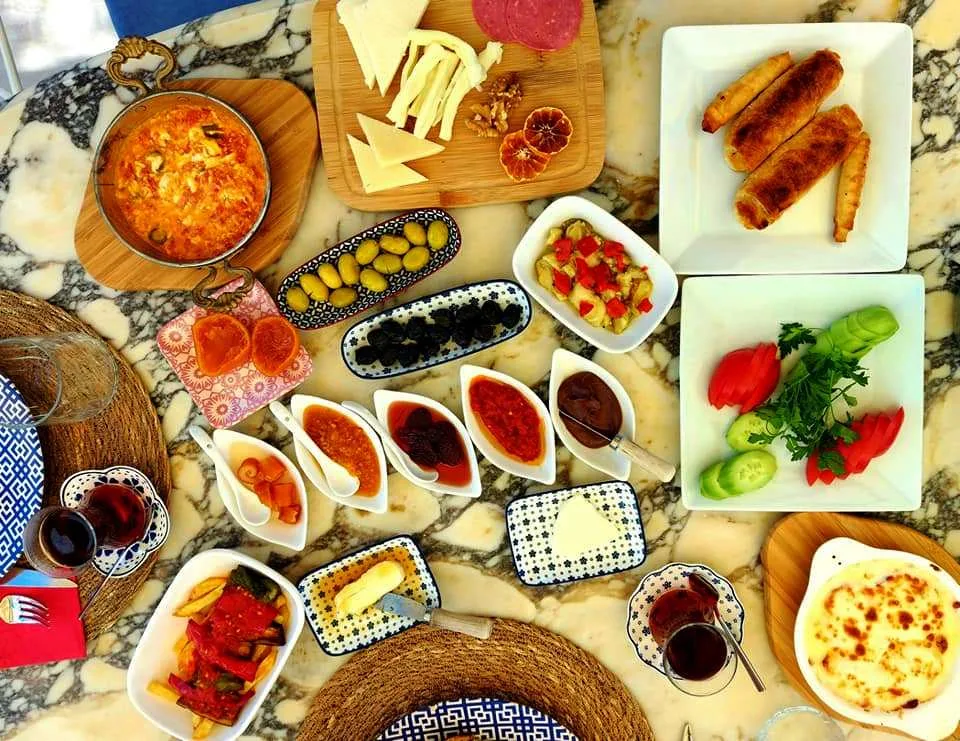 A serpme breakfast spread: menemen, cheeses, olives, jams and çay