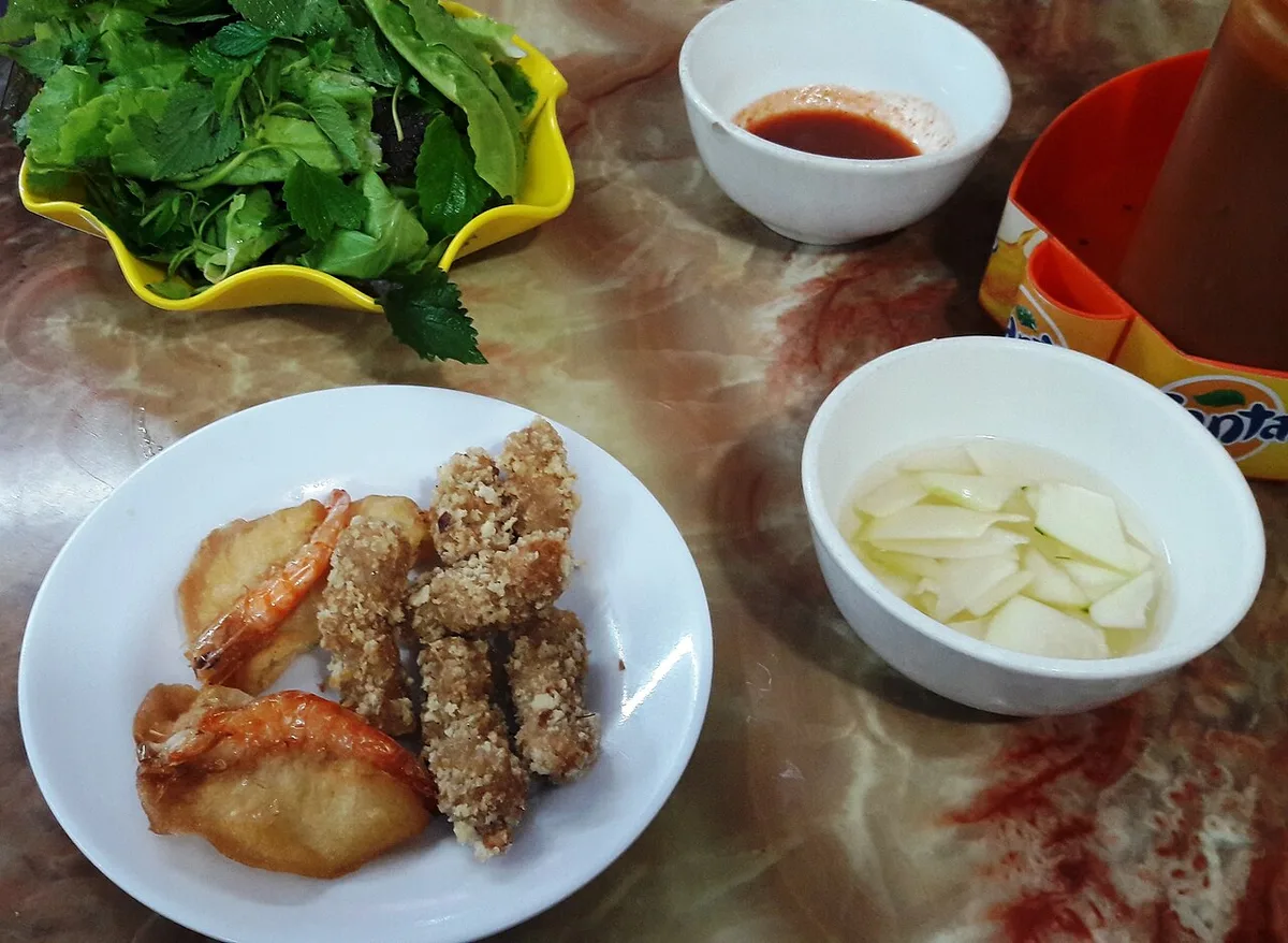 Banh tom: shrimp fritters with herbs and pickles, a market-gate snack