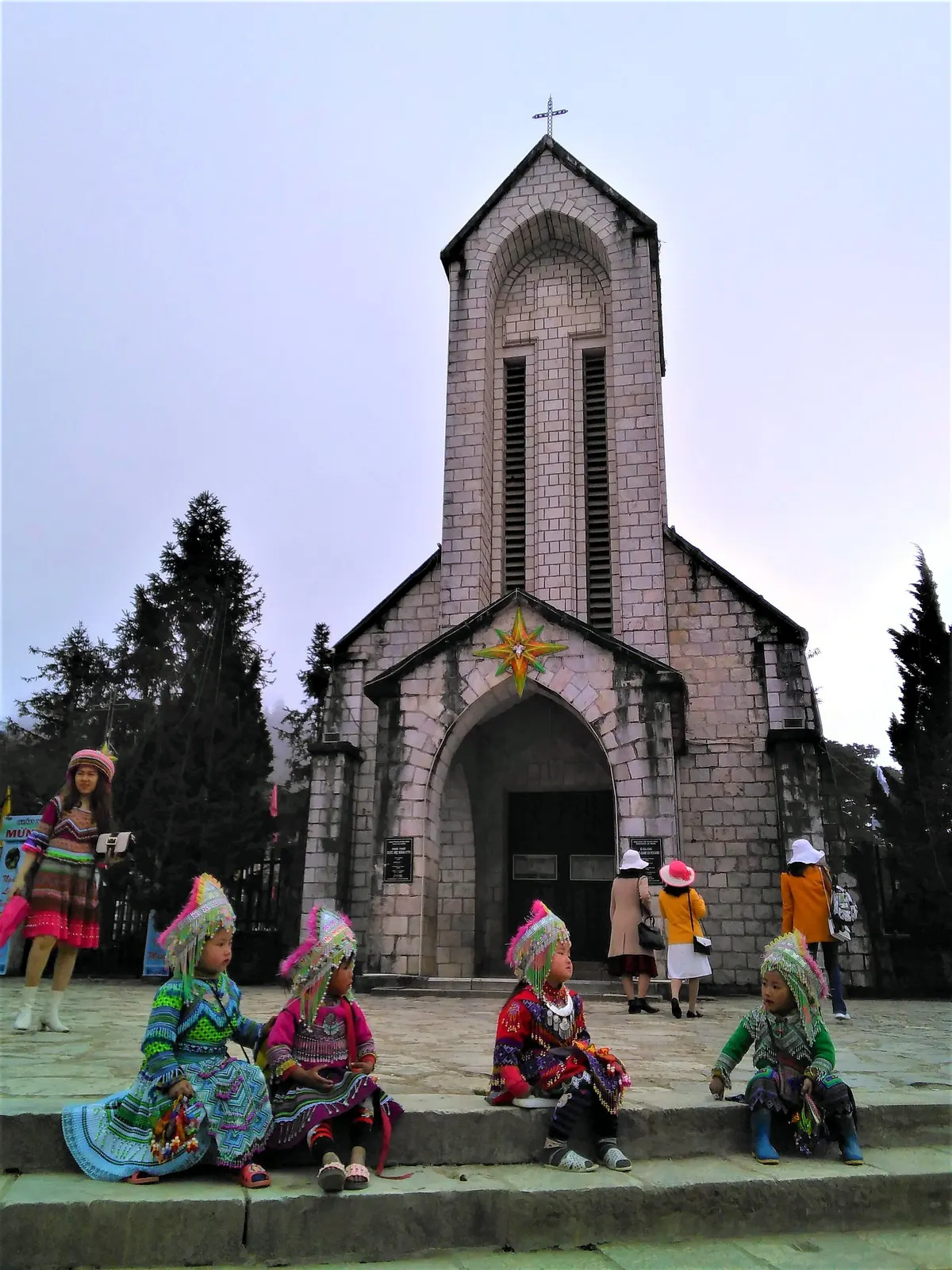 The stone church of Sapa (1895), with Hmong children in traditional dress